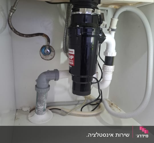מתקן טוחן אשפה מתחת לכיור במטבח